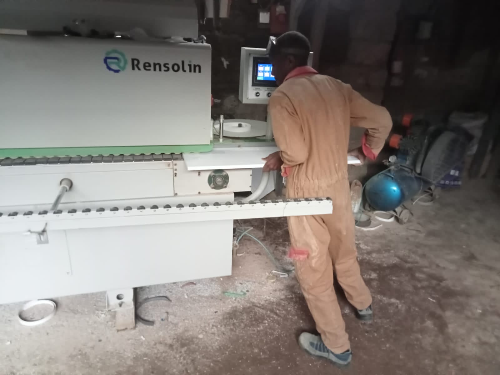 employee of ngemi interiors and hardware using edge lipping machine for cut to size board finishing in Kenya