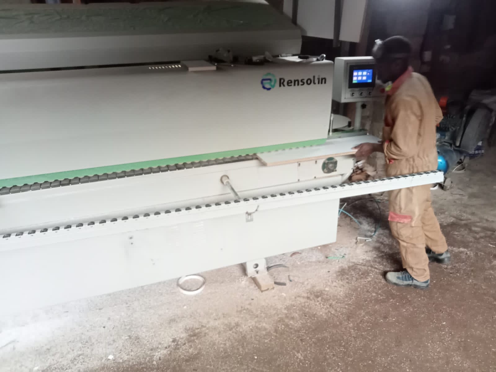 mahine operator processing final edge banding protective film on an already cut to size piece of board at machine appliued edge lipping service provider ngemi interiors and hardware east africa kamakis ruiru